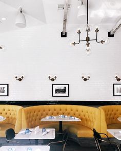 an empty restaurant with white walls and yellow booths