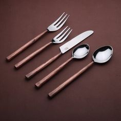 five spoons, two forks and one knife on a brown surface