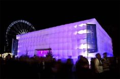 people are standing in front of an illuminated building