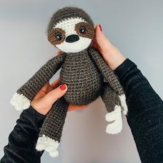 a person holding a stuffed slotty animal in their hands with the other hand on top of it