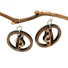 "These gyroscope circle earrings appear simple but possess constantly changing visual intrigue. Three concentric circles encompass one another, creating multiple facets with continual movement and interest. Three tones of wood - walnut, cherry, and maple - add further texture and detail. Laser cut wood earrings can be dressed up or down, making them the perfect complement to any outfit! These earrings are strong but so lightweight and comfortable, you will hardly know you have them on! Pair with Modern Brown Round Jewelry, Laser Cut Wood Earrings, Laser Cut Earrings, Concentric Circles, Cut Earrings, Silver Earrings Handmade, Printed Jewelry, Silver Dangle Earrings, Gifts For Wine Lovers