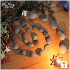 rocks arranged in the shape of a hand on a wooden table next to a lit candle