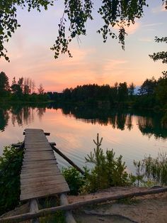 a wooden dock sitting on the side of a lake