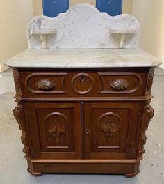 an old fashioned wooden cabinet with marble top