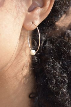 These timeless pearl hoops are made by hand and have a slight irregularity. Wear this classic shape daily or for a night out on the town. These make a great gift, easily worn for years by earring wearers of all ages and tastes. A variation of our Classic Hoops with a pearl. Product Details: -Available in solid sterling silver or 14k gold fill -Hammered 1.25in hoop with a hook clasp sold as a pair. -Pearl is an AAA-grade freshwater pearl that measures 5-6mm. All items are hand made to order, thus Everyday Hoop Jewelry With Pearl Charm, Everyday Silver Hoop Earrings With Pearl Charm, Everyday Pearl Charm Hoop Earrings, Small Pearl Hoop Earrings For Everyday, Everyday Pearl Hoop Jewelry, Small Hoop Earrings With Pearl Charm, Everyday Small Pearl Hoop Earrings, Minimalist Everyday Hoop Earrings With Pearl Charm, Minimalist Handmade Pearl Earrings For Everyday