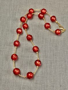 "Perfect for your holiday party this red Murano glass beaded necklace will add luxury and style to your outfit! The glass artisan beads have a subtle texture to them that adds to their personality and charm. Each handmade bead has genuine 14k gold foil within it. The necklace measures 19.5 inches with gold fill lobster claw clasp. A perfect gift for any occasion and arrives in a standard gift box. * Matching earrings are available at this link: https://www.etsy.com/listing/1596931806/murano-glas Holiday Gold Beaded Jewelry, Red Round Beads Jewelry For Festive Occasions, Festive Red Round Beads Jewelry, Elegant Beaded Jewelry For Holidays, Elegant Red Single Strand Necklace, Red Spacer Beads Jewelry Gift, Handmade Red Beaded Necklaces For Celebration, Red Spacer Beads Jewelry As Gift, Elegant Red Jewelry With Spacer Beads