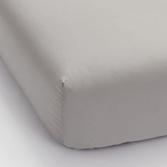 a close up view of a bed with white sheets