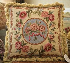 a pillow with flowers on it sitting on a table next to some baskets and other items