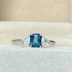 Teal Sapphire Engagement Ring White Gold, Emerald Ring With Sapphire Accent Stones, Emerald Sapphire Ring With Accent Stones, Blue Asscher Cut Three Stone Jewelry, Blue Three Stone Asscher Cut Jewelry, Blue Three-stone Asscher Cut Jewelry, Blue Emerald Ring With Round Cut, Sapphire Ring With Radiant Cut And Accent Stones, Sapphire Radiant Cut Ring With Accent Stones