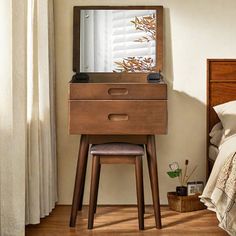 a bedroom with a bed, dresser and mirror on the wall next to a window