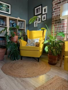 a living room filled with furniture and lots of plants on top of a hard wood floor