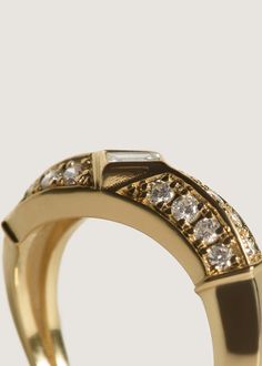 This ring's unique curved body is vintage inspired and will never go out of style. Featuring a baguette diamond surrounded by sixteen round diamonds. Hollow and designed with comfort in mind. 14k solid gold—always Average weight: 3.9g Band width: 5.5mm thick (front), 2.5mm (back) Baguette carat weight: 0.14ctw Round carat weight: 0.36ctw Diamond cut: Round and Baguette Diamond clarity: SI1-2 This piece is made to order. Please allow at least 4-6 weeks for production. Timeless Diamond Ring With Baguette Diamonds, Luxury Diamond Ring With Rose Cut Baguette Diamonds, Luxury Baguette Cut Diamond Ring With Rose Cut Diamonds, Luxury Rose Cut Diamond Ring With Baguette Shape, Luxury Baguette Cut Rose Cut Diamond Ring, Heirloom Diamond Ring With Baguette Diamonds, Luxury Diamond Ring With Single Cut Baguette Diamonds, Luxury Baguette Cut Ring With Single Cut Diamonds, Luxury Emerald-cut Diamond Ring With Rose Cut Diamonds