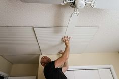 a man is working on a ceiling fan