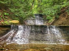 a small waterfall in the middle of a forest