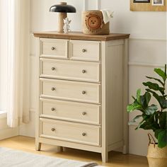 a chest of drawers in a room with a potted plant next to it and an animal figurine on top