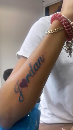 a woman with a tattoo on her arm that reads jordan and has hearts in it