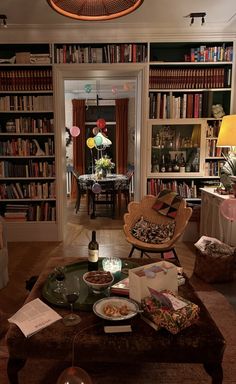 a living room filled with furniture and bookshelves next to a dining room table