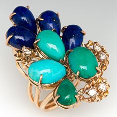 This striking vintage ring is accented with four (4), prong set, cabochon cut natural turquoise, four (4), prong set, cabochon cut natural lapis lazuli and five (5), prong set, round brilliant cut diamonds. The ring measures 33.4mm at the top, rises 22.0mm above the finger, tapering to 3.9mm wide and 1.3mm thick at the base of the shank. This ring is currently a size 3. Turquoise Cocktail, Vintage Turquoise, Vintage Ring, Natural Turquoise, Brilliant Diamond, Oval Cabochon, Vintage Diamond, Round Brilliant Cut Diamond, Cocktail Ring