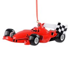 a red race car ornament hanging from a christmas tree on a white background