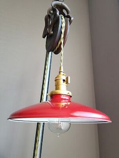 a red light hanging from a ceiling with a rope attached to the top of it