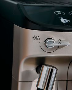 an espresso machine with a smiling face on the front and side buttons,