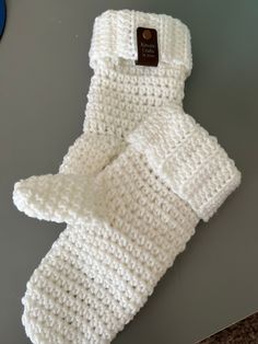 a white knitted mitt sitting on top of a table