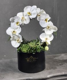 a white flower arrangement in a black vase