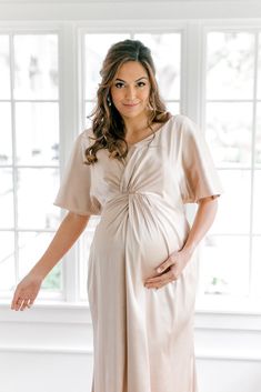 Our graceful Gwen Satin dress has been modified with a higher waistline and extra room to accommodate a growing bump, becoming the perfect option for the mommy-to-be in your bridal party! While a little more modest in coverage, the Gwen still features flutter sleeves and a delicate front twist detail that adds sophistication to a timeless design. FEATURES: Empire silhouette V-neckline Built-in bra cups and vertical boning for support Dolman flutter sleeves Back zipper Full-length double lining f Modest Maternity Dress With Short Sleeves, Elegant Ruched Maternity Dress For Spring, Elegant Maternity Ruched Dress, Elegant Maternity Dress With Ruched Detail, Elegant Ruched Maternity Dress, Elegant Ruched Midi Dress For Maternity, Elegant Ruched Midi Maternity Dress, Elegant Maternity Dress Nursing Friendly, Elegant Nursing-friendly Maternity Dress