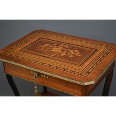 an ornate wooden table with gold trimmings on the top and sides, decorated with flowers