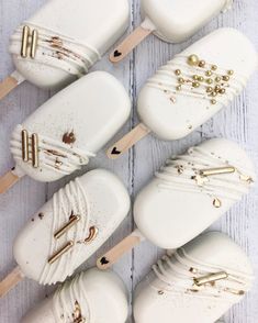 white chocolate covered pops with gold sprinkles on wooden skewers, ready to be eaten