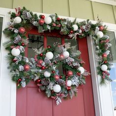 a christmas wreath on the front door of a house