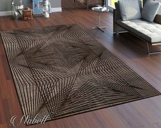 a living room area with hardwood flooring and large rugs on the wooden floor