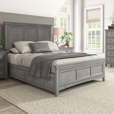 a bedroom with a bed, dressers and two night stands in the middle of it