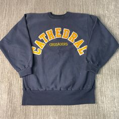 Vintage 90s Champion Reverse Weave Cathedral Crusaders Arc Logo Sportswear 1990s Fashion Navy Graphic Crewneck Extra Large Mens *W17 Condition:  Fair Used Condition  = Some Stains Throughout The Sweatshirt Due To Age And Wear  Measurements: Please see photos above for all measurements IF YOU BUY TWO OR MORE ITEMS USE THE CODE BUNDLE @ CHECK TO SAVE 20% WE SHIP WITHIN 24 HOURS AFTER PURCHASE! Please be aware that we do not offer free returns!! The Buyer is responsible for the cost of the return label. Follow us on TikTok & Instagram @findsnostalgic and tag us in your finds Team-colored Throwback Sweatshirt For Sports, Varsity Tops With University Logo For Streetwear, Sporty University Logo Tops For Streetwear, Throwback Crew Sports Top, Sporty Streetwear Tops With University Logo, Throwback Crew Top For Sports, Throwback Sports Sweatshirt With Graphic Print, Throwback Graphic Print Sweatshirt For Sports, Varsity Sweatshirt With Team Name For Streetwear