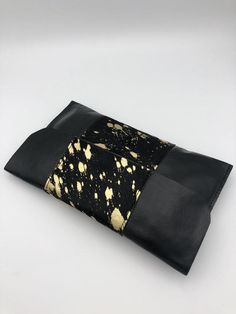 Made using the finest quality leather, this clutch is super stylish and unique!  A beautiful black hair on leather with metallic gold flecks! It measures 10 inches in width and 6 inches in height. It is fully lined with a black leather interior. The perfect size for your cell phone, keys and lipgloss. Gold Leather Clutch For Evening, Textured Leather Clutch Wallet For Evening, Designer Gold Leather Clutch, Modern Gold Leather Clutch, Gold Leather Pouch Clutch, Black Textured Leather Evening Clutch, Gold Leather Wallet For Evening, Black Textured Leather Rectangular Clutch, Gold Leather Evening Wallet