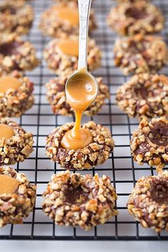 a spoon is being drizzled with caramel sauce on top of cookies