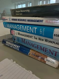 a stack of books sitting on top of a desk