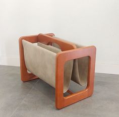 an orange and brown chair sitting on top of a floor next to a white wall