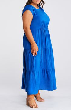 A flowy tiered skirt adds gorgeous movement to this essential maxi dress finished with drawstring gathering to define the waist. 51" length (size 16) Jewel neck Cap sleeves Unlined 100% viscose Dry clean or machine wash, line dry Imported Blue Flowy Tiered Maxi Dress, Beach Tiered Maxi Dress With Elastic Waistband, Beach Maxi Dress With Elastic Waistband And Tiered Shape, Beach Maxi Dress With Elastic Waistband And Tiered Design, Flowy Blue Rayon Maxi Dress, Blue Flowy Rayon Maxi Dress, Flowy Blue Tiered Maxi Dress, Flowy Ruched Tiered Midi Dress, Flowy Ruched Tiered Skirt Maxi Dress