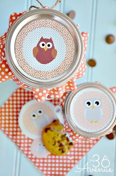 two tins with owls on them sitting next to each other in front of an orange and white checkered table cloth