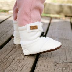 Our Stay-Put Cozy Booties are guaranteed to stay on the most active little kickers!    Stay-Put Design: Adjustable elastic drawstring around ankle and easy Velcro tab  Cozy: Made with soft and warm fleece  Flexible Soles: Durable PU soles, reinforced at toe and heel  Lightweight: Perfect for babies and first-time walkers  Easy Care: Machine washable on gentle cycle, air dry   Back to Stay Put Baby Booties | See all Infant Footwear Winter Playtime Booties With Soft Sole, Comfortable Soft Booties For Playtime, White Winter Booties For Playtime, Winter White Booties For Playtime, Comfortable Winter Booties With Soft Sole, Non-slip White Winter Boots, Cozy Winter Booties With Soft Sole, White Non-slip Winter Boots, Casual Winter Booties With Plush Lining