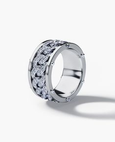 a white gold ring with diamonds on the outside and in the middle, against a white background