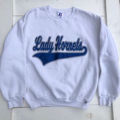 90s Lady Hornets Sweater, Fitted White Pullover Sweatshirt, 90s Cheer Sweatshirt, 90s Cheerleader Sweatshirt, Vintage Lady Hornets Size Medium Made in El Salvador Russell Athletic 50% Cotton 50% Polyester Measurements: Shoulders- 21 inches Chest- 43 inches Sleeve length- 22 inches Length- 24.5 inches B6 90s Style Sweatshirt For Game Day, 90s Crew Neck Tops For Game Day, 90s Style Tops For Game Day During Sports Season, 90s Style Tops For Game Day And Sports Season, 90s Long Sleeve Top For Game Day, 90s Style Long Sleeve Tops For Game Day, 90s Style Tops For Game Day, White Throwback College Sweatshirt, White 90s Crew Sweatshirt