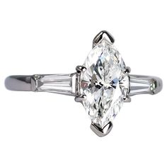 This sweet engagement ring features the next trending shape for engagement rings in a timeless setting. The center diamond is a 1.01 carat marquise certified by GIA to be D color and I1 clarity. The tapered baguettes are 0.68 carats total, and draw your eye to the center diamond and add a touch of sparkle to the platinum setting. Purchase includes complimentary ring sizing, ring box, and original GIA grading report. Engagement Ring With Tapered Baguettes, Tapered Engagement Ring, Marquis Diamond, Marquise Diamond Engagement Ring, Ring Inspiration, Marquise Diamond Ring, Engagement Ring Inspiration, Jewelry Styles, Marquise Ring