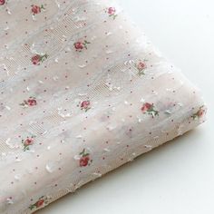 the fabric is white with pink flowers on it