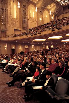 a large group of people sitting in front of an audience at a conference or seminar