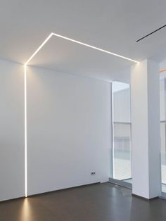 an empty room with white walls and lights