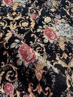 an ornate black and red rug with flowers on it