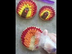 cookies decorated like turkeys with icing and decorations on them are being held by someone's hand