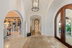 a hallway with arched doorways leading to another room